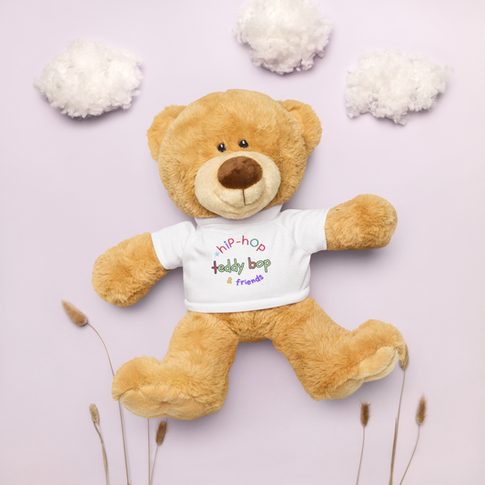 Teddy bear wearing a t-shirt with colorful text on a light purple background with decorative elements.